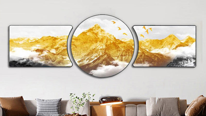 Three mountain-themed wall art pieces on a white wall above a sofa.
